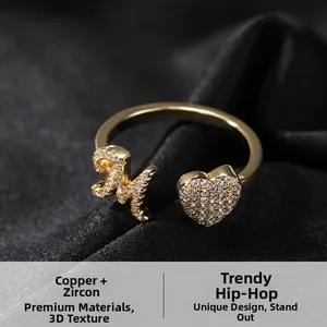 Dettaglio dell'anello aperto in rame con cuore di zirconi e lettera M stile hip hop