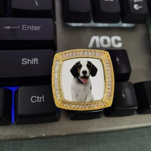 Vista macro dell'anello quadrato dorato con zirconi e dettaglio foto cane personalizzata
