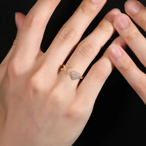 Dettaglio dell'anello dorato regolabile con lettera K e cuore in micro-pave di zirconi