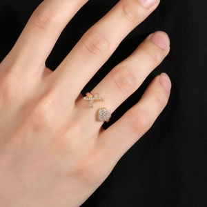 Primo piano dell'anello regolabile a cuore in oro con pavé di zirconi su sfondo nero
