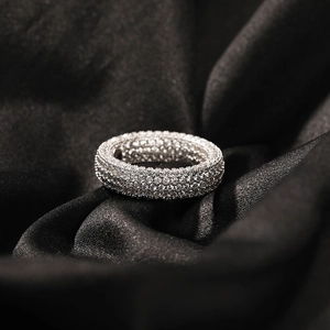 Dettaglio anello in argento con zirconi micro-pave su sfondo di raso nero
