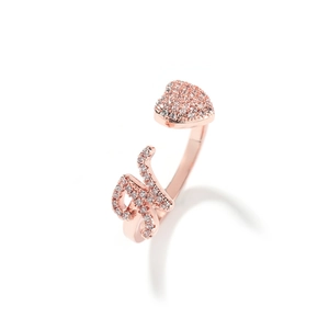 Dettaglio anello regolabile in oro rosa con cuore di zirconi e ciondolo lettera K