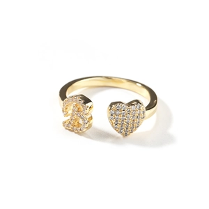 Dettaglio anello dorato aperto con cuore di zirconi e numero tre in micro-pavé