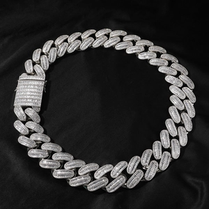 Gros plan sur une chaîne cubaine avec zircons taille baguette sur soie noire élégante