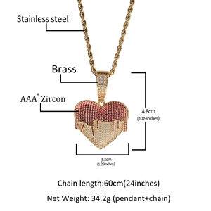 Detailed view of heart pendant necklace with red and white zircons on a gold rope chain