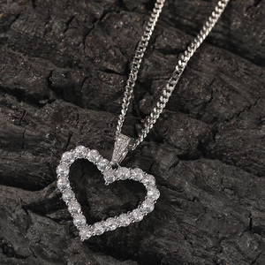 Close-up of sparkling heart pendant with cubic zirconia and silver cuban chain
