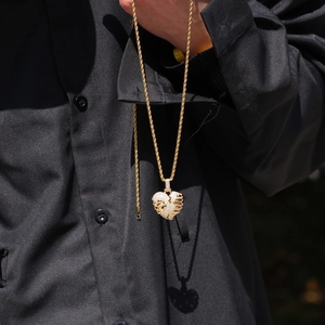 Macro view of iced out heart pendant with white zircons on a golden rope chain