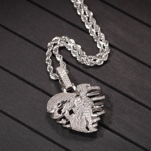 Macro shot of silver heart pendant with white zircon stones and twisted rope chain