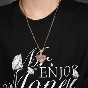 Close-up of heart pendant necklace with pink and white stones on a rope chain