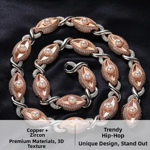 Detail van de oogvormige koperen schakels met zirkonia en witte parels aan de ketting