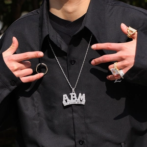 Detailopname van de zilveren ABM All About Money hiphop-hanger met fonkelende zirkonia-stenen