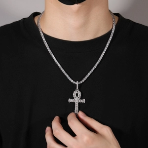 Close-up of sparkling iced-out Ankh cross pendant on 4mm tennis chain for men