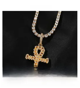 Macro view of gold Ankh cross pendant with pavé cubic zirconia on tennis chain