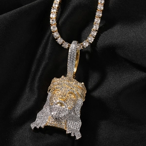 Macro shot of iced out Jesus pendant with zircon stones on a black silk background