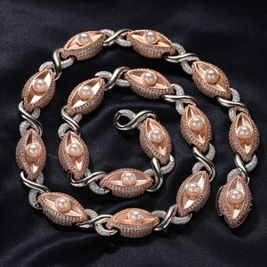 Detail van hiphop ketting met roségouden oogvormige schakels en parel accenten