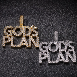 Close-up van God's Plan hiphop hangers in goud en zilver met ingelegde zirkoonstenen