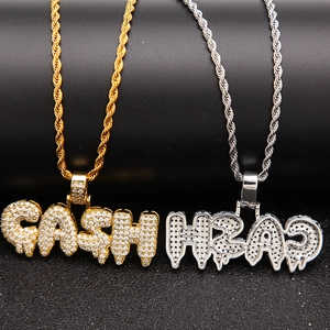 Macro-opname van gouden en zilveren CASH-hangers met zirkonia pavé en gevlochten ketting