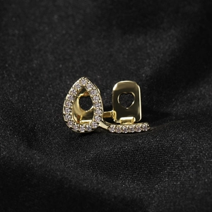 Macro view of gold-plated single tooth grillz with heart cutout and micro-pave zircons