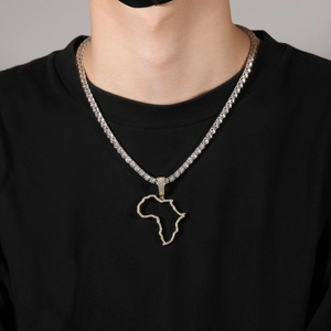 Close-up of hip-hop iced out Africa map pendant with gold tennis chain on male model