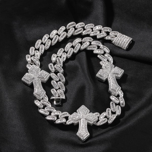 Macro detail of iced-out Cuban link chain with three large diamond-set cross pendants