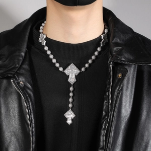 Detail der silbernen Perlen-Kreuzkette mit Zirkonia, getragen auf schwarzer Jacke