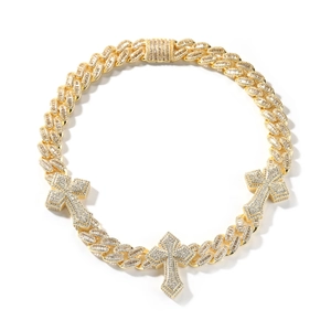 Close-up of golden Cuban link necklace with three iced out cross pendants for men