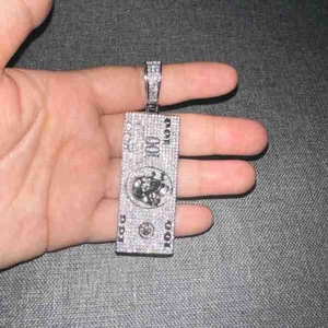 Detailed macro view of iced out 100 dollar bill pendant with skull and zircons