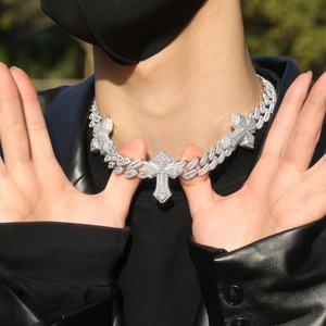 Close-up of hip hop silver Cuban link chain with paved diamond crosses on black jacket