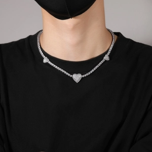 Detailweergave van hartvormige hangers aan een zirkoon tennisketting gedragen door model