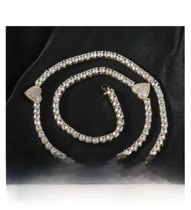 Detailopname van gouden tennisketting met hartvormige zirkonia hangers op zijden stof