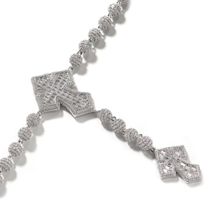 Detail der Silberkreuz-Halskette mit Zirkonia-Steinen und glitzernder Perlenkette