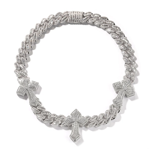 Detailed macro view of silver Cuban link chain with three iced-out cross pendants for men