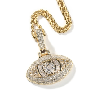 Détail macro du pendentif œil maléfique doré serti de zircons brillants de style hip-hop