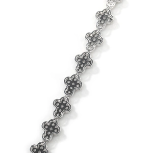 Macro detail of silver cross link bracelet with black center and sparkling zircon stones