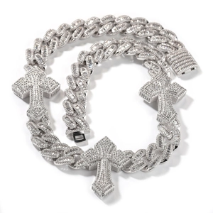 Close-up of iced out cuban chain necklace with diamond-studded cross pendants in silver