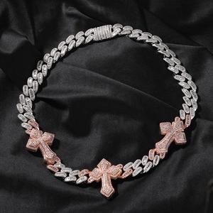 Detailed view of two-tone punk Cuban chain necklace with iced out cross pendants on silk