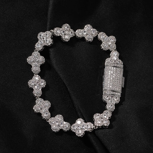 Macro shot of sparkling silver clover bracelet with zircon pavé on black silk