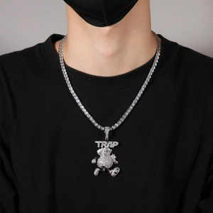 Vue détaillée de la chaîne tennis argentée avec pendentif TRAP cartoon sur mannequin
