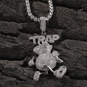 Détail macro du pendentif sac d'argent TRAP serti de cristaux et de sa chaîne tennis