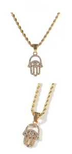 Detailed view of a gold Hamsa hand pendant with sparkling crystals on a twist chain