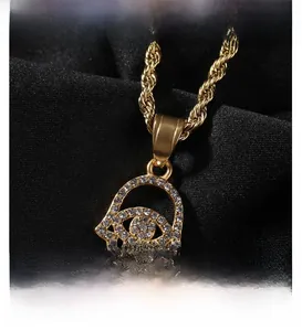 Macro shot of gold Hamsa hand pendant with pavé crystals on a twisted rope chain necklace