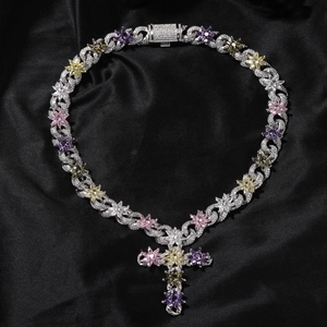 Detail of silver Cuban link necklace with colorful zircon flowers and cross pendant on satin