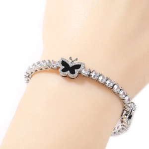 Detail shot of a silver tennis necklace featuring round cubic zirconia and a butterfly charm