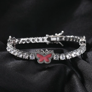 Macro shot of silver-colored tennis chain with pink butterfly on black silk background