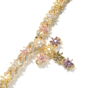 Close-up of golden cross necklace with colorful zircons and flower patterns