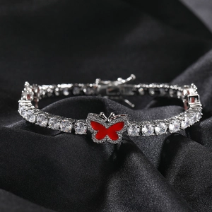 Macro shot of silver tennis chain with sparkling zircons and a red butterfly charm