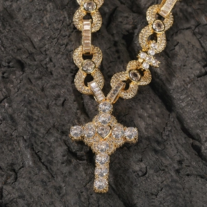 Macro view of gold-plated cross pendant with heart-shaped stone and zircon pavé detail