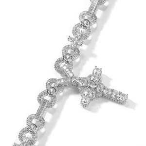 Detailed close-up of a silver cross pendant with heart-shaped cubic zirconia crystals