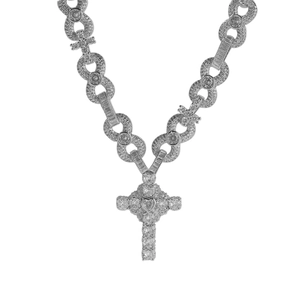 Macro detail of silver hip-hop cross necklace with heart-shaped zircon and infinity links