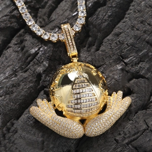 Macro shot of gold hip hop necklace featuring an iced-out earth pendant with pyramid eye